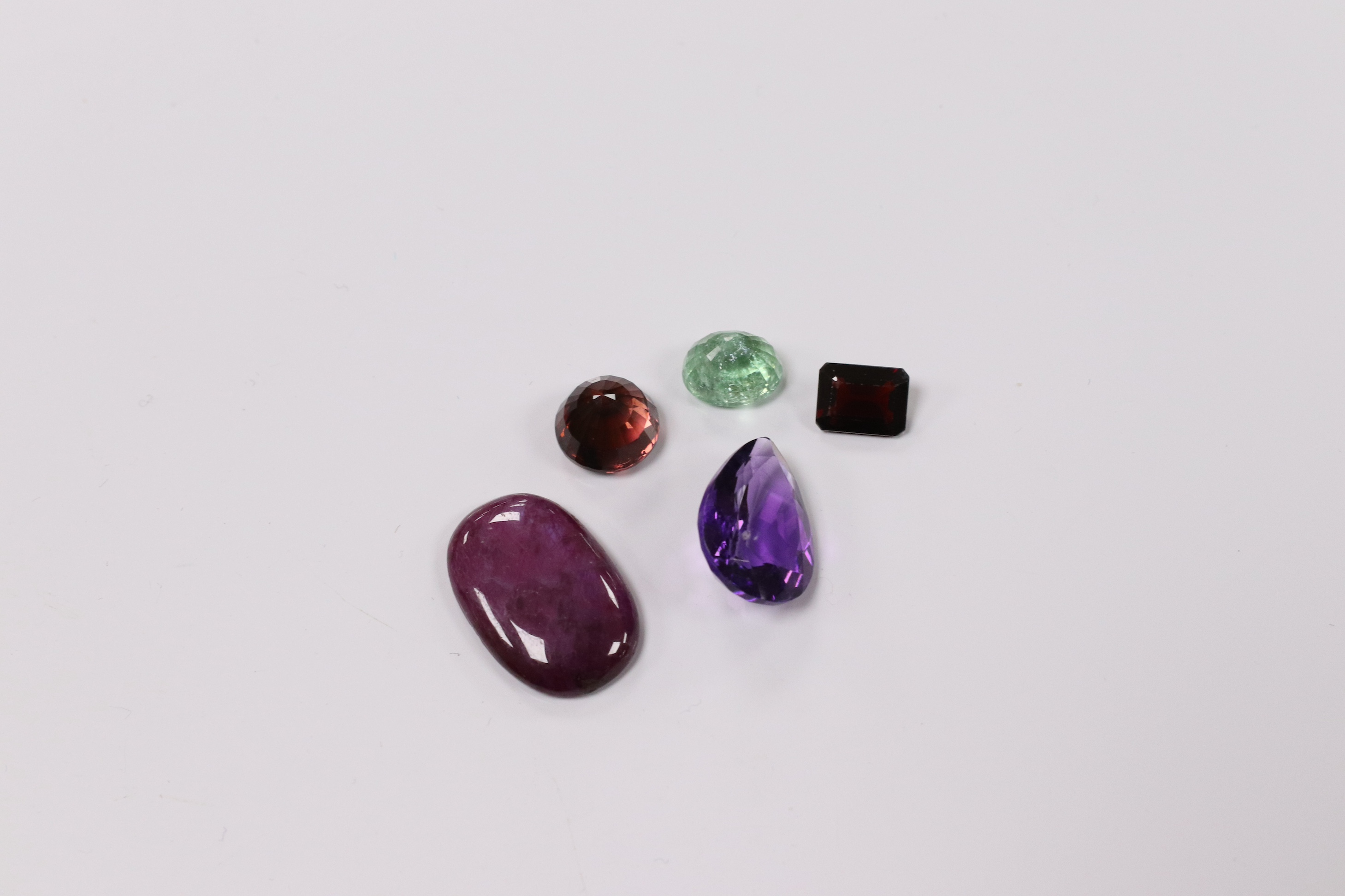 A small collection of unmounted cut gemstones, including amethyst, emerald and ruby, etc. Condition - fair